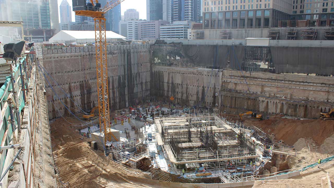 A construction site busy with activity, showcasing a tall tower and multiple workers involved in building operations