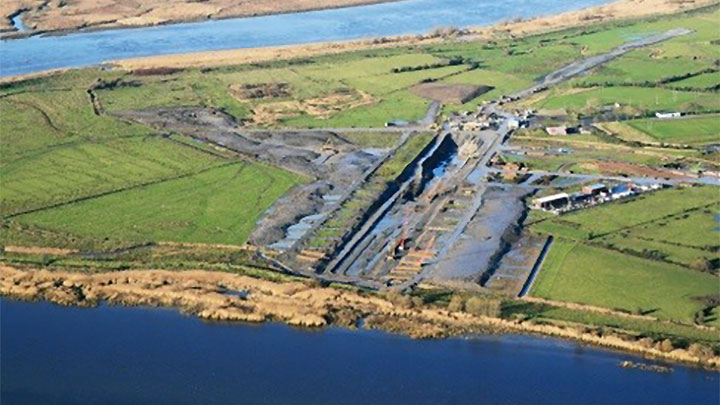 Aerial perspective of a vast industrial site with multiple buildings, roads, and infrastructure visible below