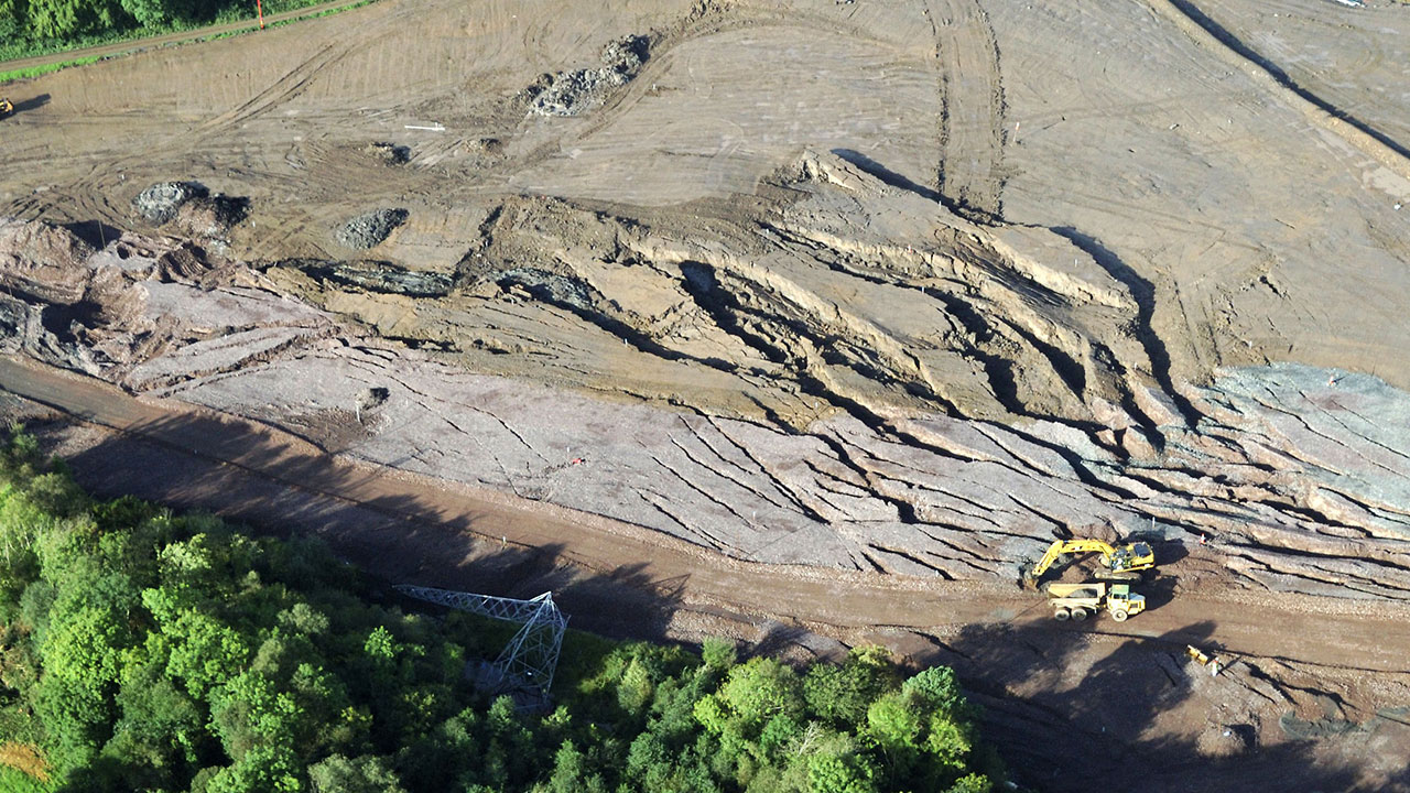 Aerial view of a construction site showing machinery, materials, and workers engaged in building activities
