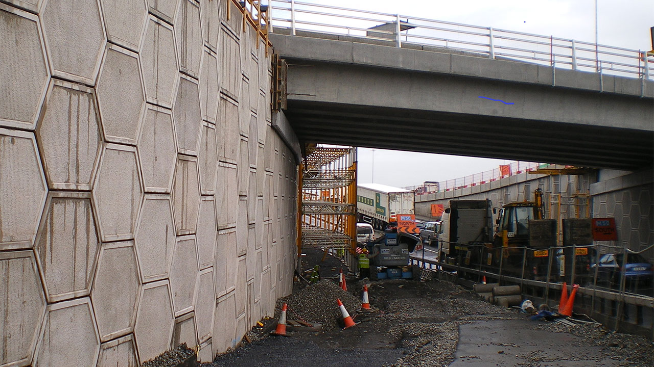 A concrete wall with a bridge spanning over it