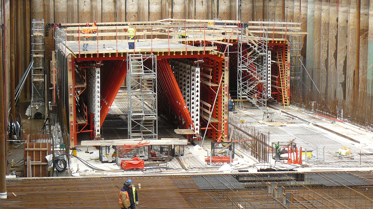 A busy construction site featuring scaffolding and workers engaged in various tasks